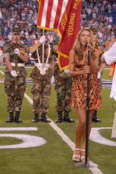 Photo of Julie Dubela singing the National Anthem at Patriots/Giants football game