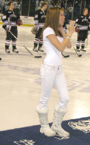 Photo of Julie Dubela singing the National Anthem at UNH hockey game